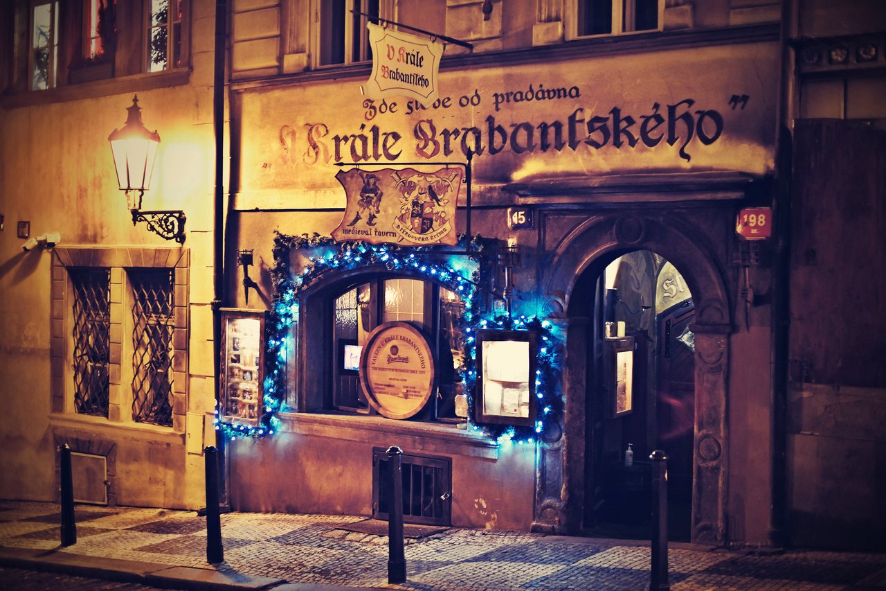 The tavern's facade, featuring a sign and a medieval emblem