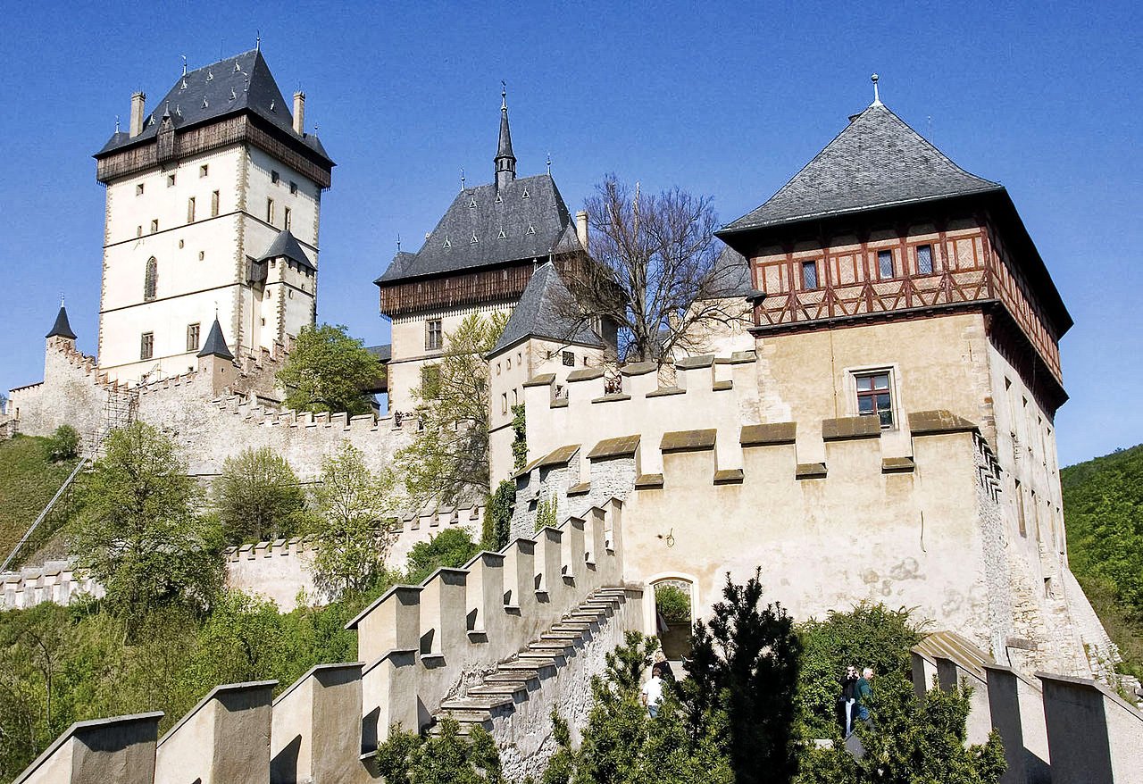 A white-stone fortress, topped with tall, pointed roofs and surrounded by ramparts