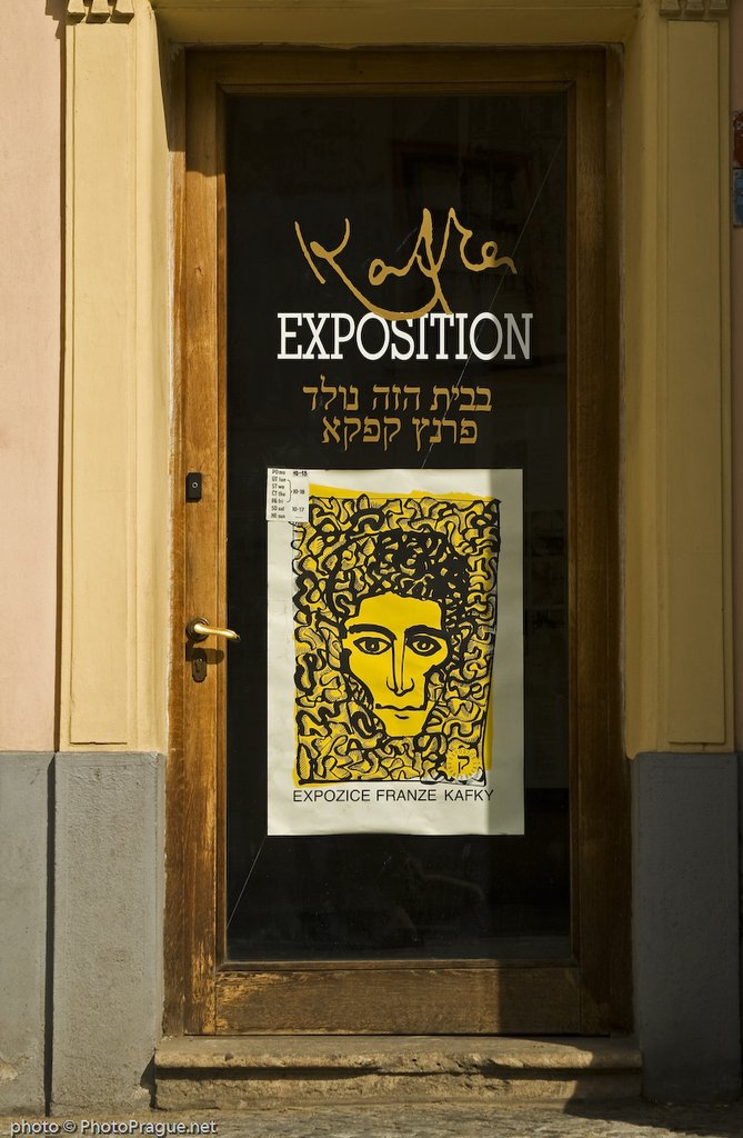 A wooden glass door with a large rectangular yellow and black poster depicting a face