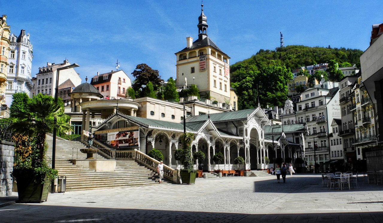 It is a long, white wooden spa building in the Swiss style, with lace-like arches and topped by a tower