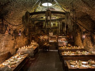 en:The interior of a medieval restaurant features a large chandelier in the center, the tables are lit by candlelight; fr:Intérieur restaurant médiéval avec un grand lustre au milieu les tables sont éclairer à la bougie